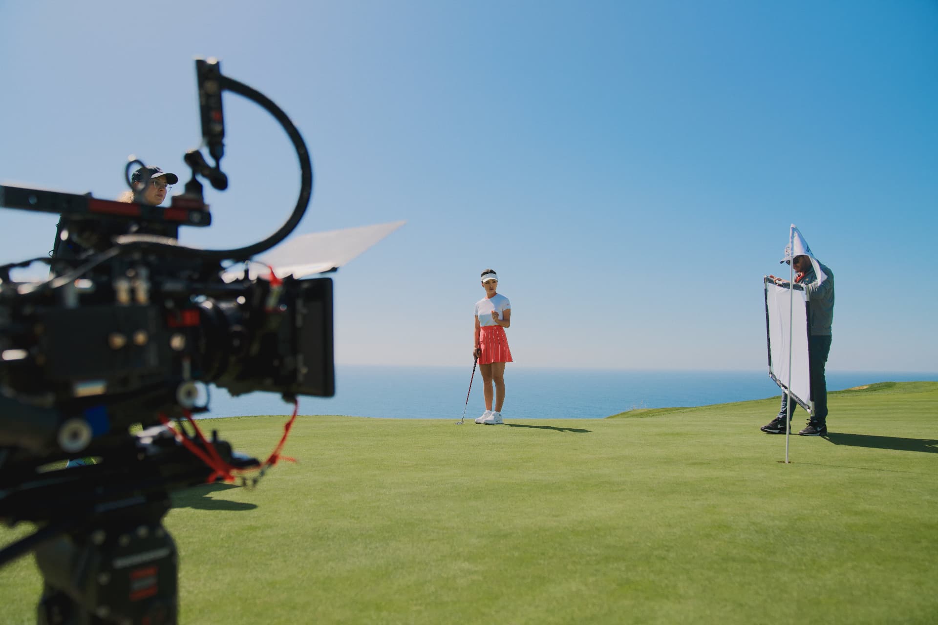 Cinema camera filming a golfer near the ocean