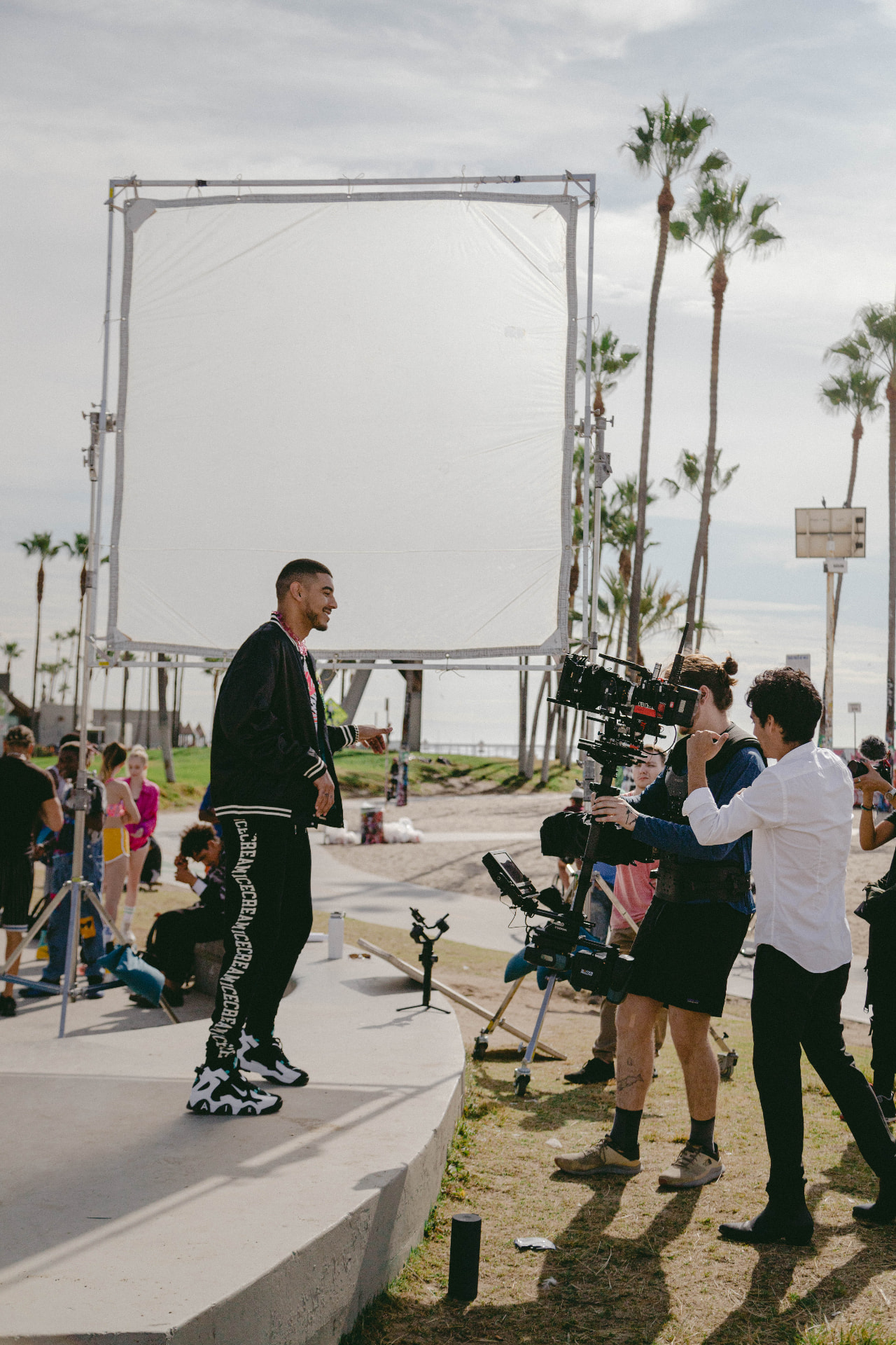 Juanma Sierra and crew filming a performer on a palm-lined promenade